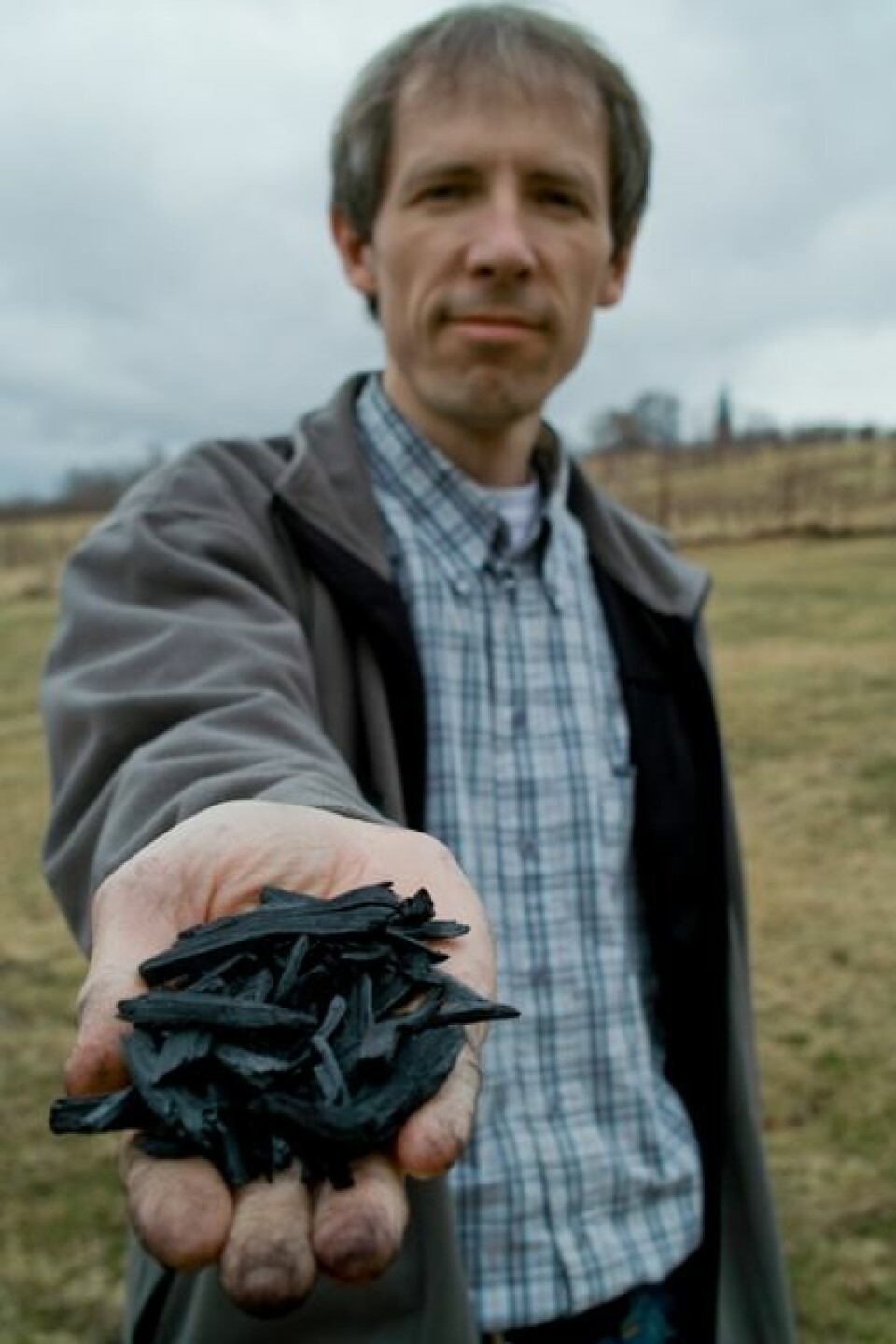 Forsker Daniel Rasse ved Bioforsk Jord og miljø med biokull som er pyrolysert og dermed stabilt og godt egnet for karbonlagring i jord. (Foto: Ragnar Våga Pedersen)