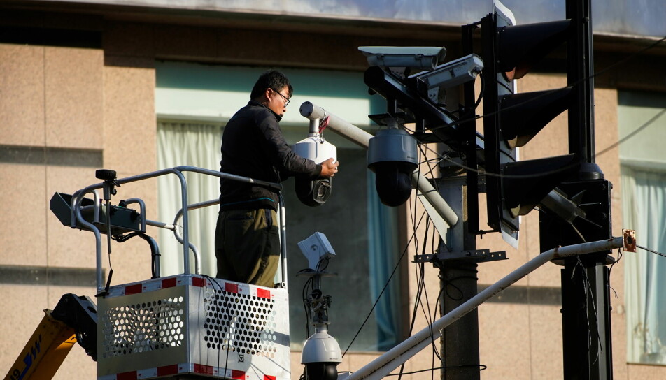 En arbeider undersøker et overvåkningskamera i Shanghai november 2021.