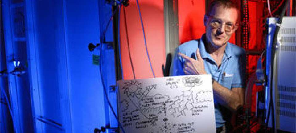 "Jasper Kirkby ved CERN foran CLOUD-prototypen. Han holder en skisse som forklarer den mulige forbindelsen mellom kosmiske stråler og skydannelse."