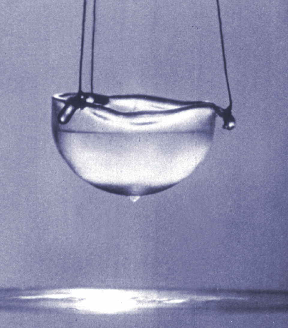 Flytende helium i superfluid fase, avkjølt til nær det absolutte nullpunkt. En tynn, usynlig hinne kryper opp langs innerveggen av koppen og ned på utsiden. Den vil falle ned i den flytende heliumen nedenfor, helt til koppen er tom. (Foto: Alfred Leitner)