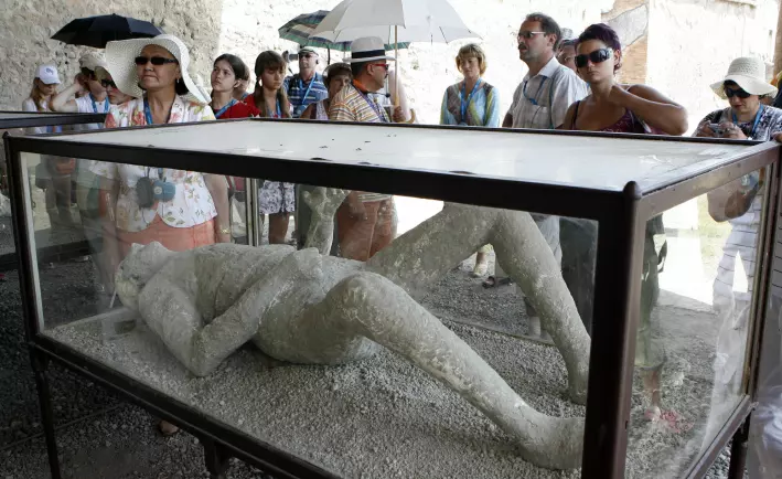 Turister seg på en mumie i Pompeii. Innbyggerne døde i den kroppsstillingen de hadde da vulkanutbruddet rammet.