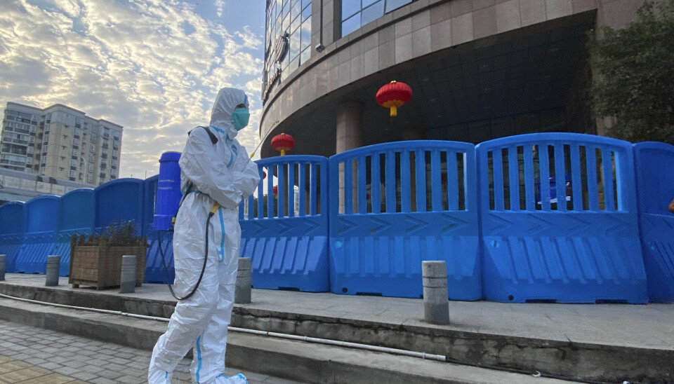 En arbeider i beskyttelsesutstyr utenfor sentralsykehuset i Wuhan 6. februar 2021. Hvordan viruset først ble spredt her, og senere i verden, er noe eksperter i Verdens helseorganisasjon (WHO) prøver å komme til bunns i.