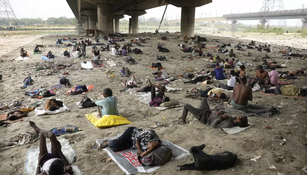 Hjemløse søker ly under en bro i et hetebølgerammet New Delhi i India. Hetebølgene forsterkes og blir verre av global oppvarming.