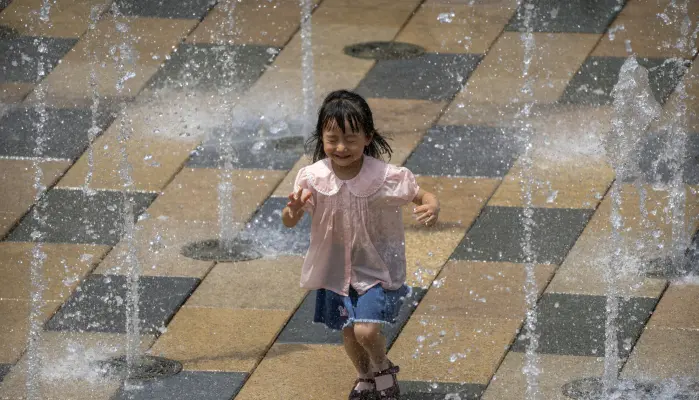 En liten jente avkjøler seg på en ekstremt varm dag i Beijing. Kina opplever den verste hetebølgen på flere tiår, samtidig som styrtregnet satte juni-rekord. En liten jente avkjøler seg på en ekstremt varm dag i Beijing. Kina opplever den verste hetebølgen på flere tiår, samtidig som styrtregnet satte juni-rekord.