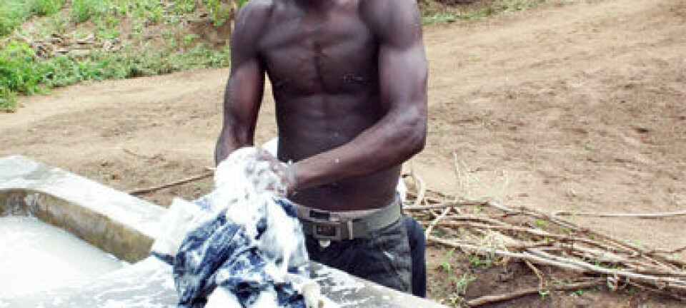 Chimwemwe Douglas vasker klær i de nye vaskene. – Vær så snill å fortell dem at vi trenger flere brønner, sier han. (Foto: Teresa Grøtan)