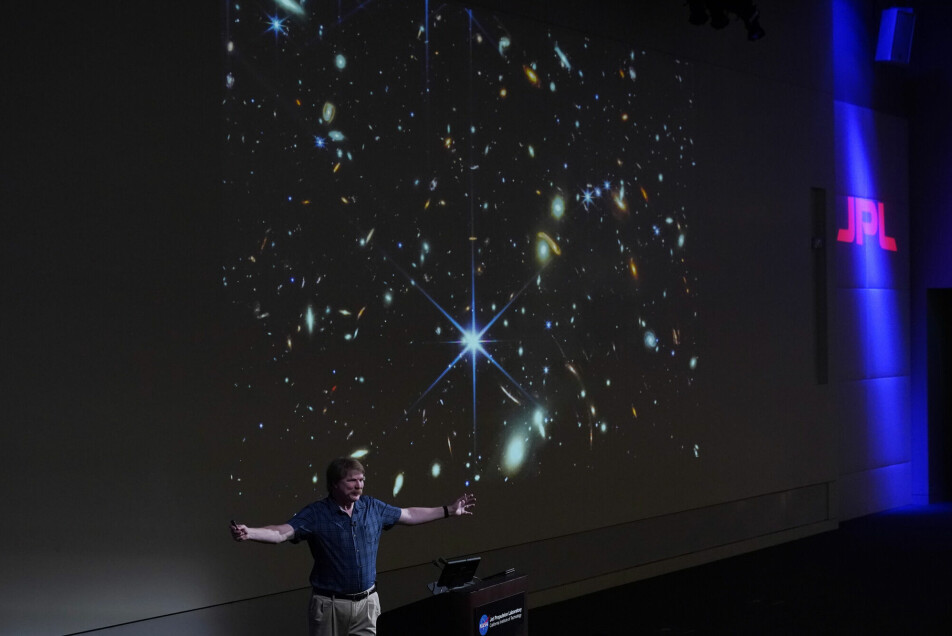 Nasa-forsker Michael Ressler under presentasjonen tirsdag. Bildet bak ham viser det dypeste og skarpeste infrarøde bildet som er tatt av det tidlige universet.