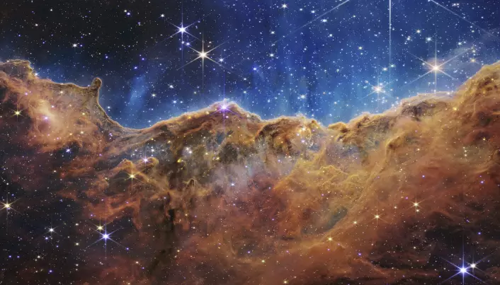 Dette bildet offentliggjort av NASA i forrige uke viser kanten av en nærliggende, ung, stjernedannende region NGC 3324 i Carina-tåken. Den ble fanget i infrarødt lys av NIRCam på James Webb Space Telescope. Bildet avslører tidligere skjulte områder med stjernefødsel, ifølge NASA.