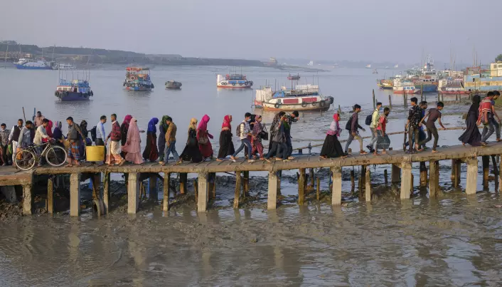 Arbeidere krysser elven Mongla i Bangladesh for å gå på jobb. Mongla er en av de første byene i verden som har gitt tusenvis av klimamigranter muligheter til å etablere et nytt liv.