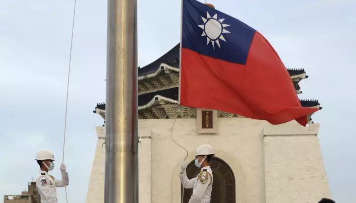 To soldater senker det taiwanske flagget lørdag.