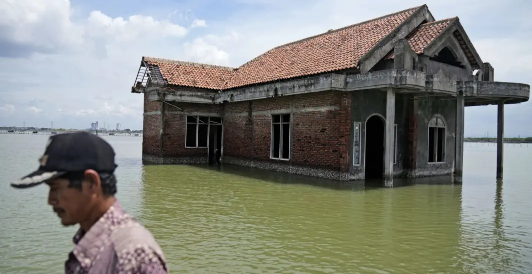 En mann går forbi et hus som ble forlatt etter at det ble oversvømmet av vann på grunn av det stigende havnivået i Sidogemah i Indonesia, 8. november 2021. Klimafarer som flom, hetebølger og tørke har forverret mer enn halvparten av hundrevis av kjente infeksjonssykdommer hos mennesker, ifølge en fersk studie. En mann går forbi et hus som ble forlatt etter at det ble oversvømmet av vann på grunn av det stigende havnivået i Sidogemah i Indonesia, 8. november 2021. Klimafarer som flom, hetebølger og tørke har forverret mer enn halvparten av hundrevis av kjente infeksjonssykdommer hos mennesker, ifølge en fersk studie.