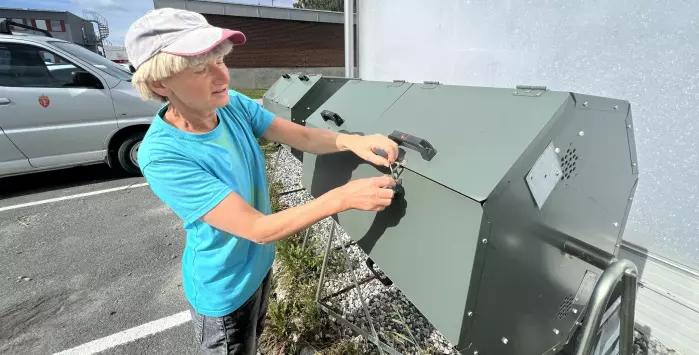 NIBIO-forsker Bente Føreid ved én av komposteringstromlene til prosjektet. Trommelen, som er godt isolert, blander inn luft og strømateriale i matavfallet når den snurres om, noe som hjelper til med komposteringsprosessen.