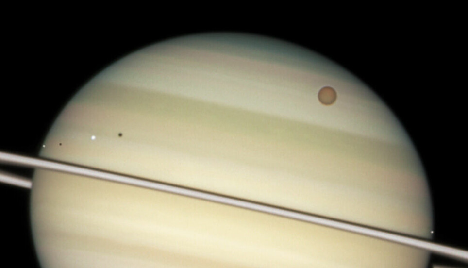 Her ser du fire av Saturns store måner, Enceladus, Dione, Titan og Mimas, på vei forbi på venstre side i bildet.