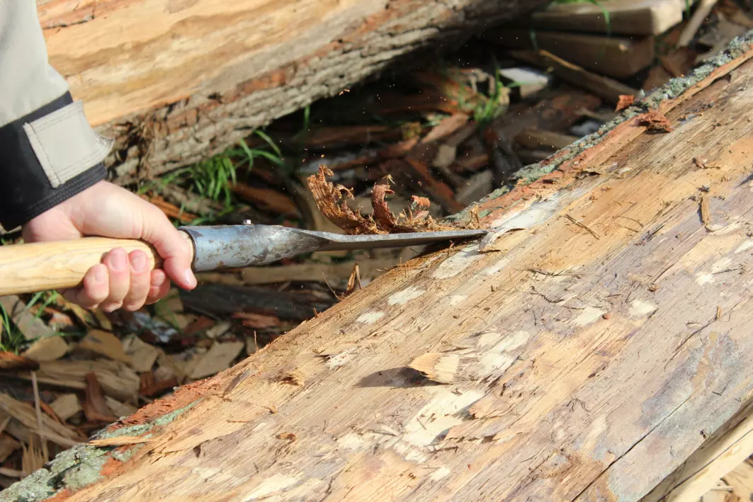 Før en stokk kløyves, fjernes barken.