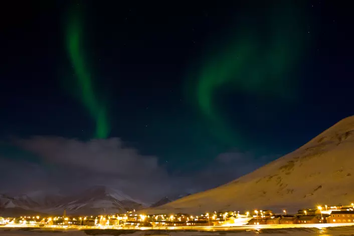 "Nordlyset leker seg over vinterhimmelen i Longyearbyen. Svalbards geografiske posisjon gjør at man har en unik mulighet til å studere dagnordlyset."