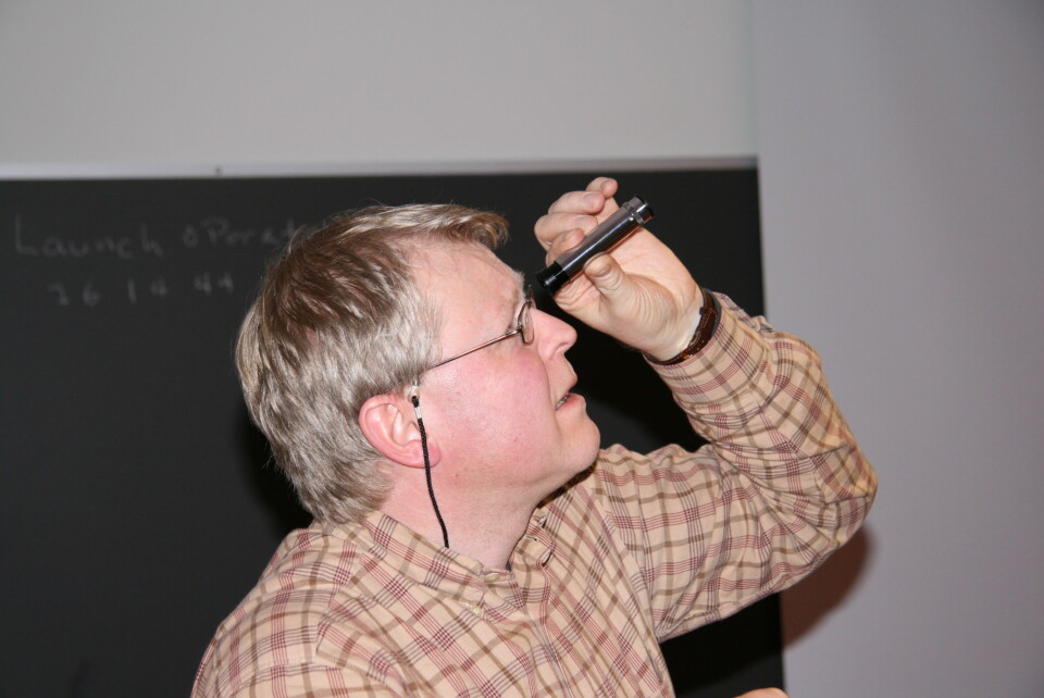 'SER LYSET: Kjartan Olafsson bruker et spektroskop til å studere lyset i taklampen på UNIS'