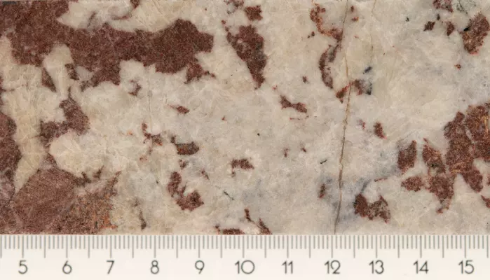 Dette er en bit av en borekjerne med brune og hvite mineraler.