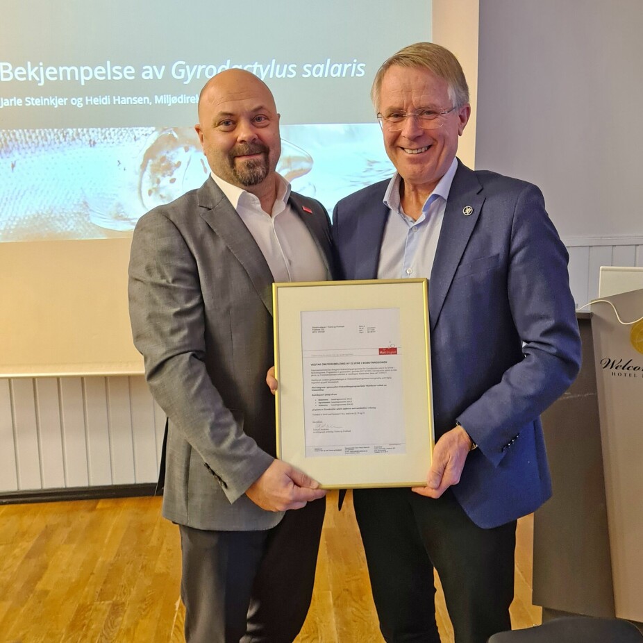 Mattilsynet har erklært Skibotn-regionen fri for G. salaris og overrekt beviset på det. Fra venstre: Geir Arne Ystmark fra Mattilsynet og Bård Pedersen fra Statsforvalteren.