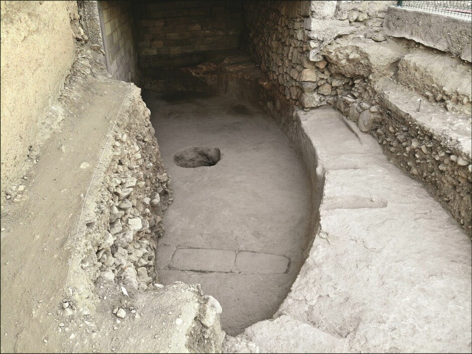 Fra utgravningen. Her har arkeologene avdekket halvparten av gulvet til forsamlingshuset, som er skåret ut av kalkstein, og ligger under mer moderne bygg. Bildet er skåret inn i benken du ser på bildet.