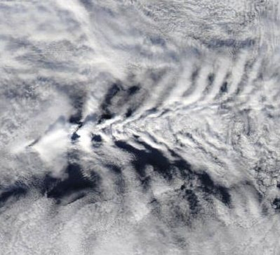 Hmmm, hva i all verden er dette? Det er nok vår gamle venn Jan Mayen som brøyter seg fram gjennom motvinden der ute i Norskehavet 27. mars. (Foto: (NASA Aqua MODIS))