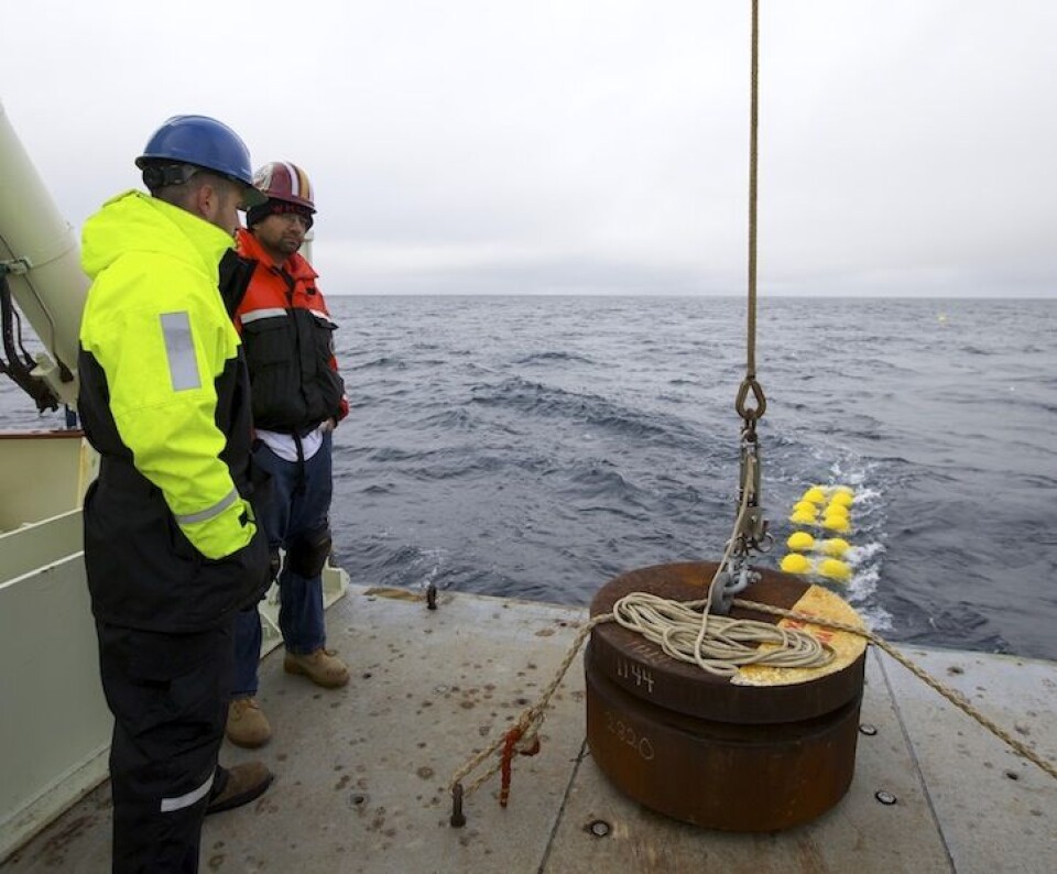 Anker på akterdekket - snart klargjort for slipp. I bakgrunnen sees bøyer som henger helt på bunnen, og langt bak til høyre kan man skimte den gule bøyen som nå slepes etter skipet. Foto: Sindre Skrede