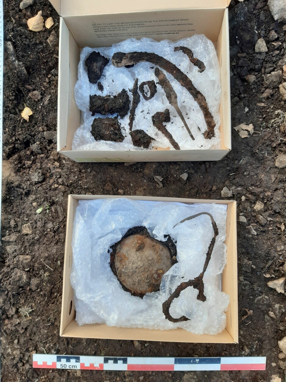 Flere av gjenstandene som ble avdekket ved graven. I boksen nederst kan du se restene av ringspennen som gir en foreløpig datering til funnet.