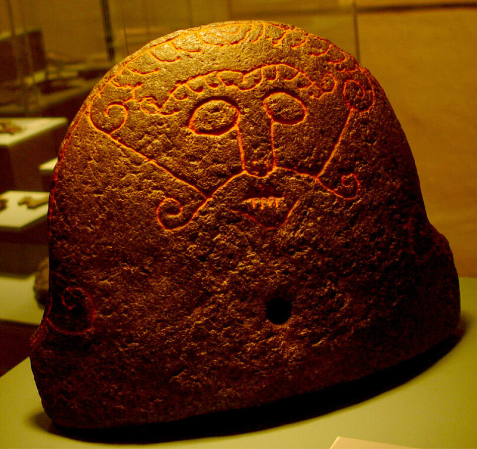 Denne dekorerte steinen viser kanskje Loke som ligg og bles på glørne, slik som Oskefisen i barndomen. Blåsebelgfront frå ei smie i Snaptun på Jylland, rundt år 1000.