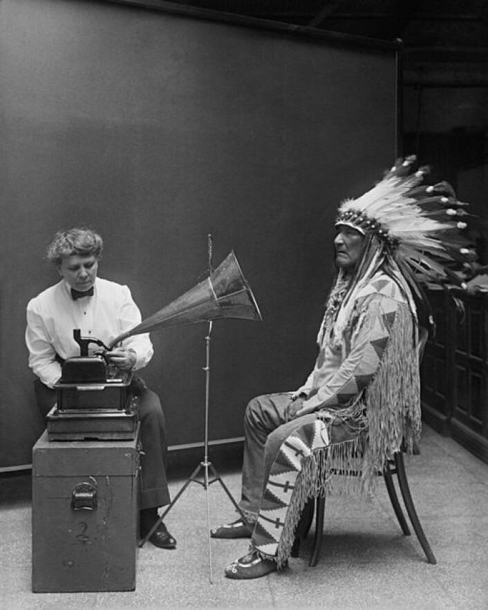 @img:2:center:size=full@ Den amerikanske musiketnologen Frances Densmore spelar in Blackfeet-hövdingen Ninastoko (Mountain Chief) på Smithsonian Institution i 1916. Densmore hade stor respekt för de människor och kulturer hon jobbade med och åtnjöt stort förtroende av de urfolksrepresentanter vars musikkultur hon dokumenterade. (Foto: Bilden er tagen från Wikimedia Commons.) @img:2:center:size=full@ Den amerikanske musiketnologen Frances Densmore spelar in Blackfeet-hövdingen Ninastoko (Mountain Chief) på Smithsonian Institution i 1916. Densmore hade stor respekt för de människor och kulturer hon jobbade med och åtnjöt stort förtroende av de urfolksrepresentanter vars musikkultur hon dokumenterade. (Foto: Bilden er tagen från Wikimedia Commons.)