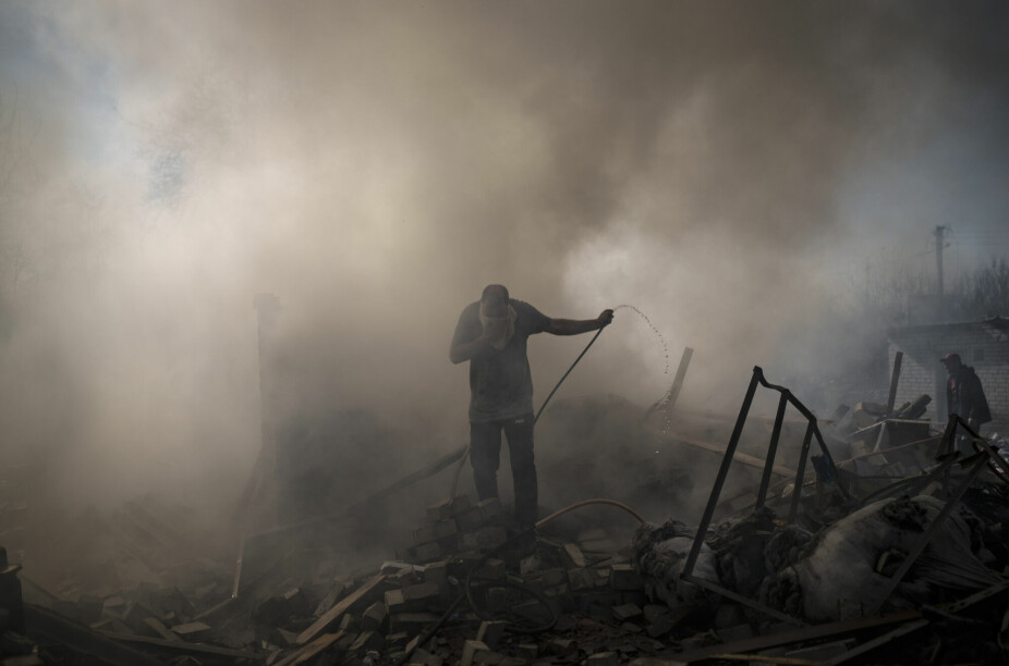 Naboer forsøker å slokke brann med en hageslange etter et russisk angrep mot den ukrainske byen Kharkiv i mars i år. Kriseeksperter frykter en rask oppskalering dersom Vladimir Putin skulle ta i bruk taktiske atomvåpen i Ukraina.