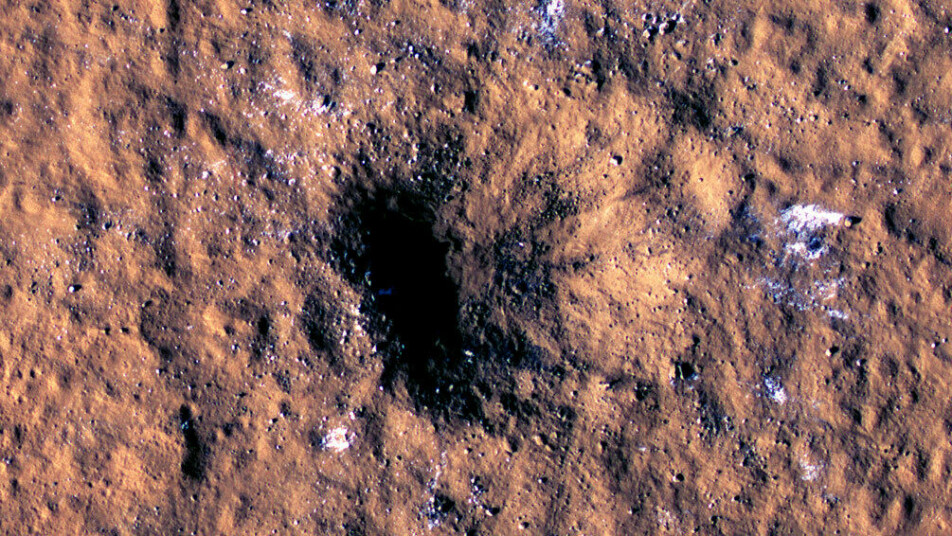 Bildet av krateret etter det kraftigste meteornedslaget InSight registrerte. Blokker av is kan ses rundt krateret.