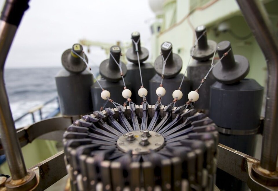 Niskin-flaskene kan når som helst lukkes fra laboratoriet ombord i skipet. Når forskerne vil lukke en flaske, sendes et signal til CTD-rosetten. Flaskene lukkes etter tur i et bestemt mønster; på bildet ville flaske nr 1, lengst til venstre, lukkes først. Kroken som holder tauet, ville sluppet taket, og flasken lukkes. Det er et tilsvarende lokk nederst på flasken. Lokkene holdes sammen med svært kraftige stålfjær. Se film over for en demonstrasjon av mekanismen. Foto: Sindre Skrede
