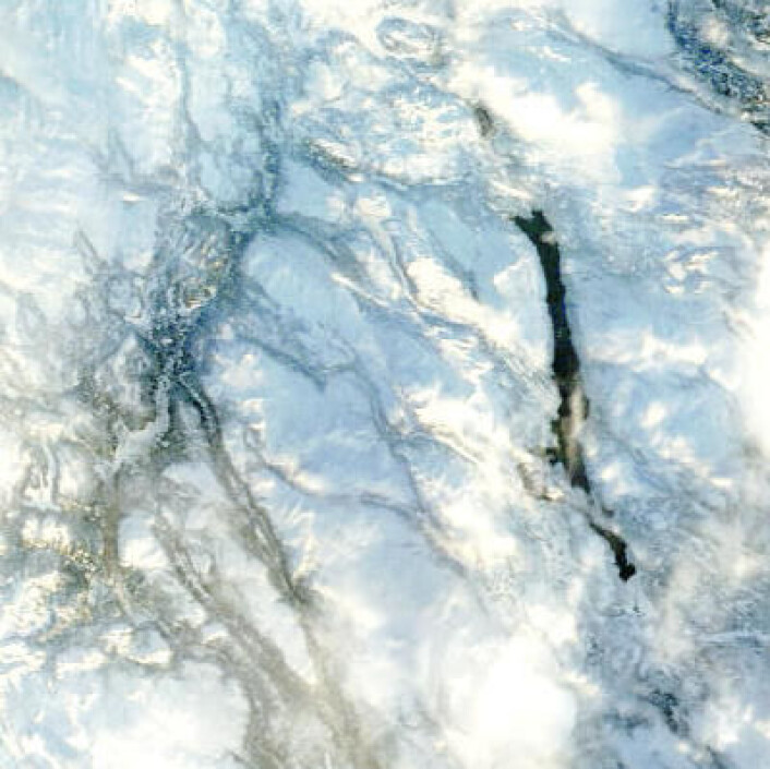 En isfri Femunden skimtes gjennom skyene 29. desember i dette bildet fra NASAs satellitt Terra. Temperaturen ved Drevsjø har vært 6 grader høyere enn normalen for desember. (Foto: (NASA Terra MODIS)) En isfri Femunden skimtes gjennom skyene 29. desember i dette bildet fra NASAs satellitt Terra. Temperaturen ved Drevsjø har vært 6 grader høyere enn normalen for desember. (Foto: (NASA Terra MODIS))