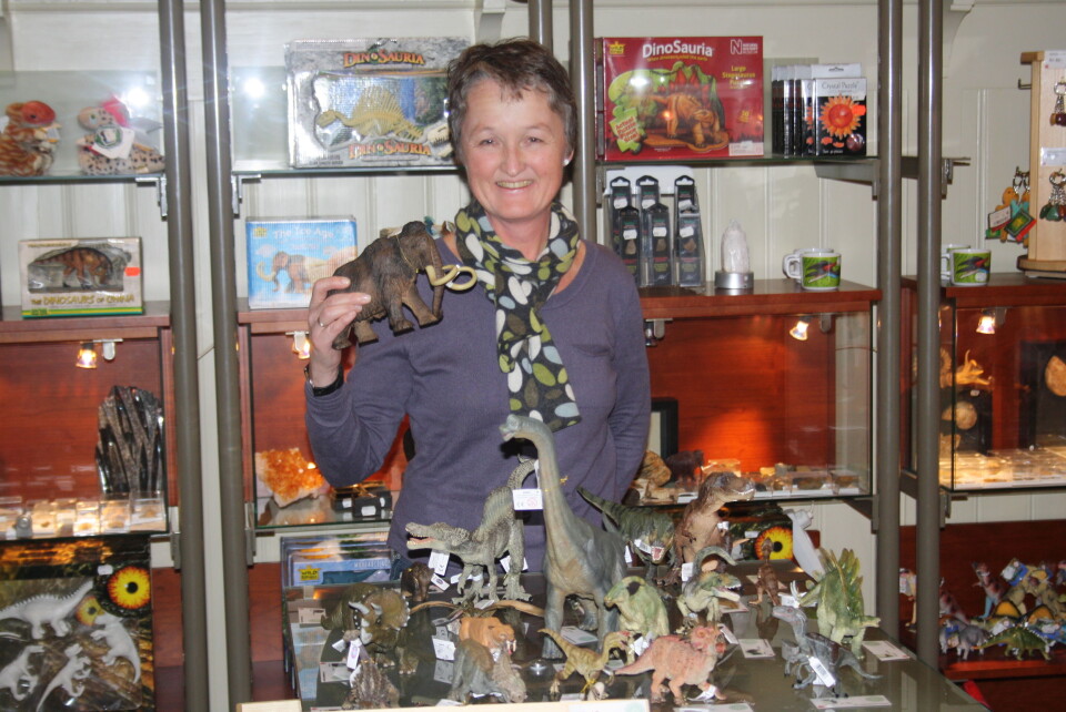 Butikkleder Hanne Lene med en modell av de mange forhistoriske dyrene du kan få kjøpt på Naturhistorisk Museum. Foto: (Foto: Erlend A.H. Saugstad)