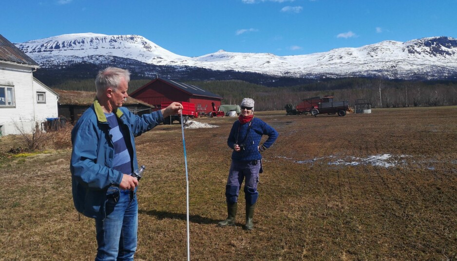 Gårdbruker Øystein Iselvmo i Målselv kommune måler teledybden sammen med landbruksrådgiver Kristin Sørensen.