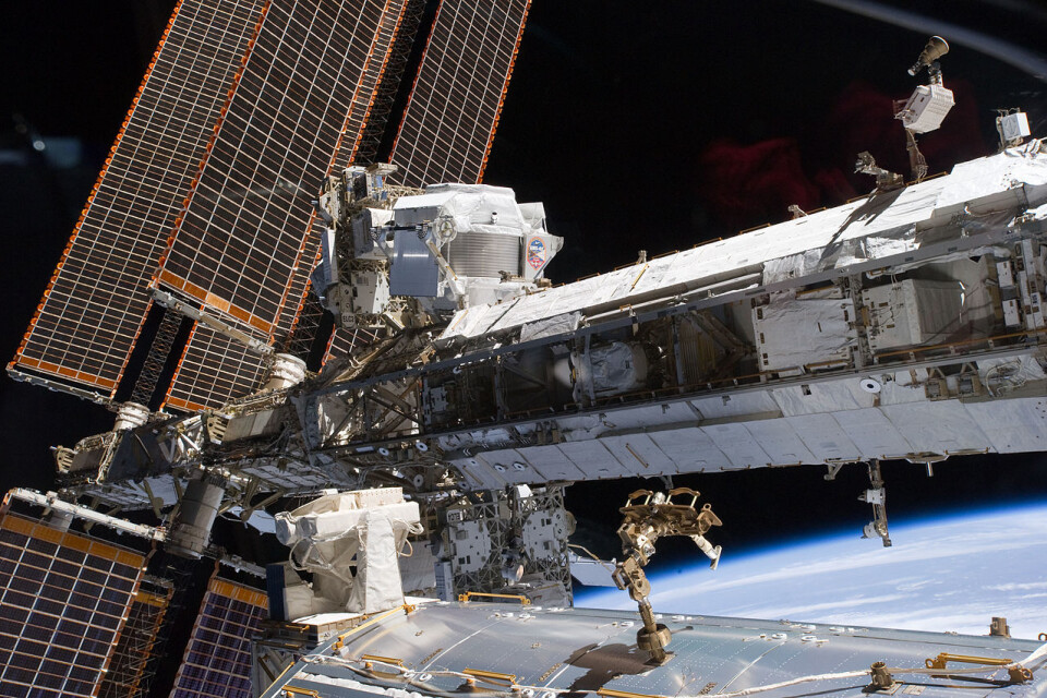 Partikkeldetektoren AMS-02 (øverst, midt på bildet) sitter på utsiden av romstasjonen og undersøker kosmisk stråling for antimaterie, mørk materie og mørk energi. (Foto: NASA/AMS-02 collaboration)