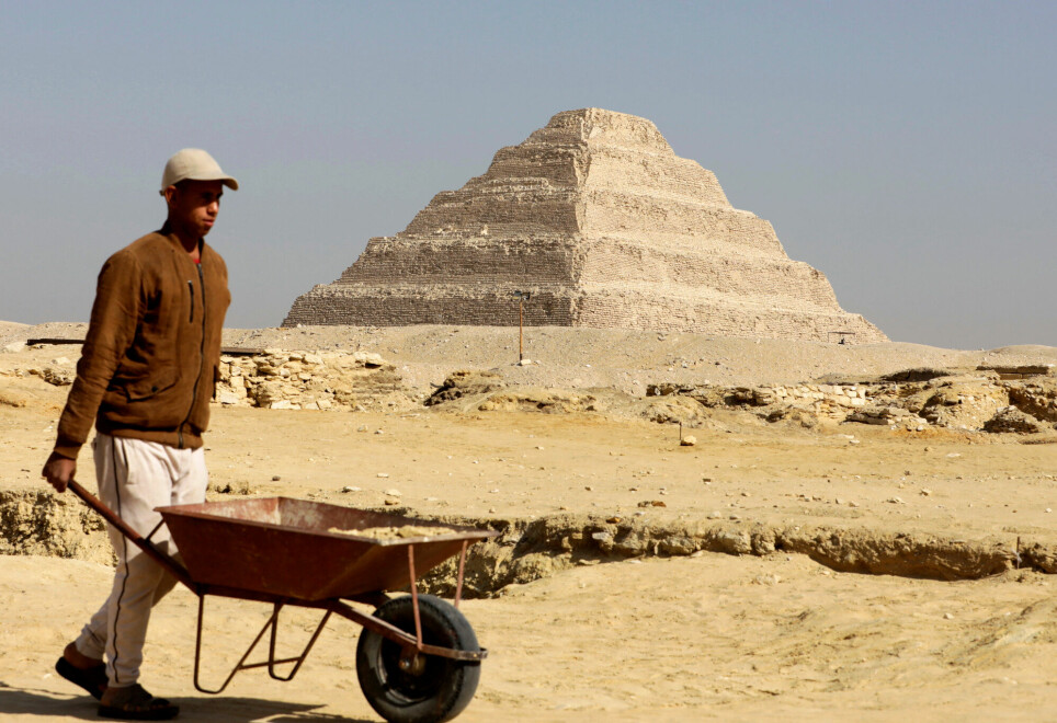 En arbeider på et arkeologisk utgravning går foran Djoserpyramiden i Saqqara. Det er her balsameringsverkstedet er funnet.