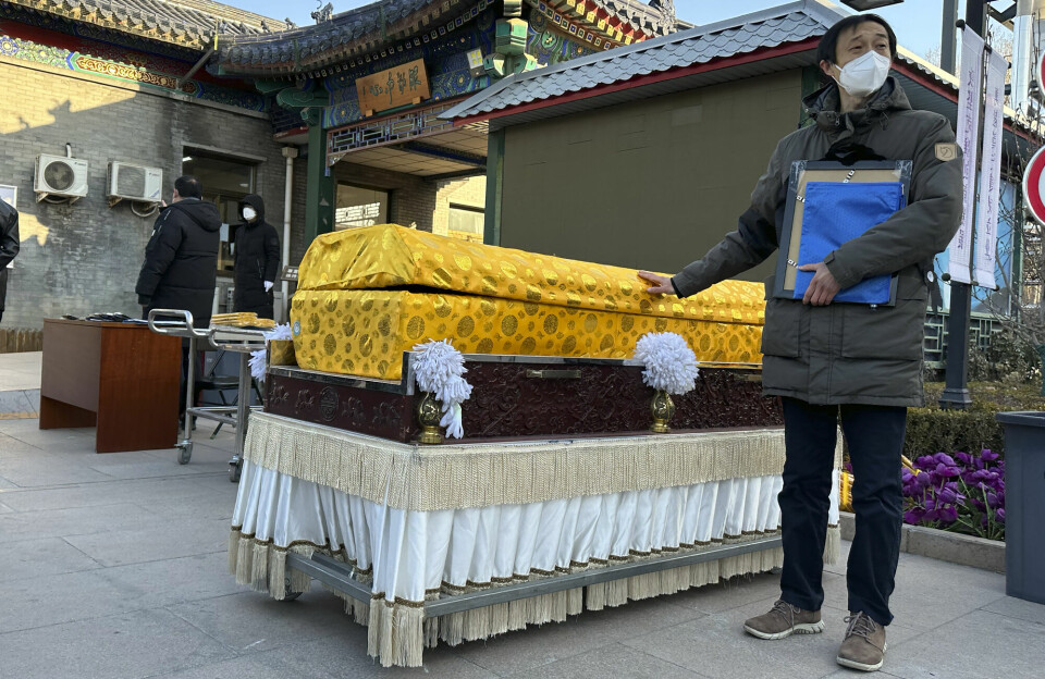 Pårørende med munnbind ved et krematorium i Beijing. Bildet er fra 17. desember i fjor.