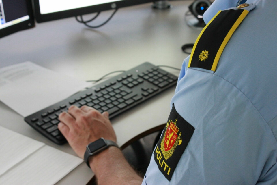 Politi i uniform skriver på tastatur.