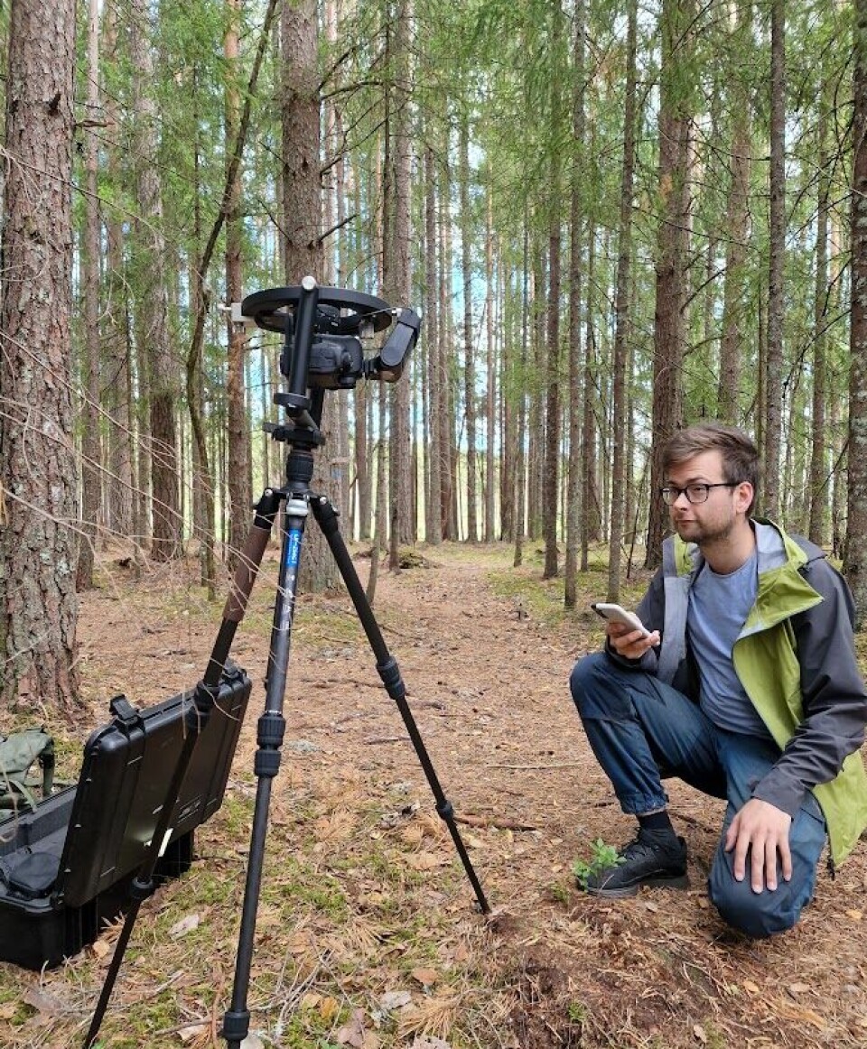 Eivind Handegard på kne foran et kamera på stativ.