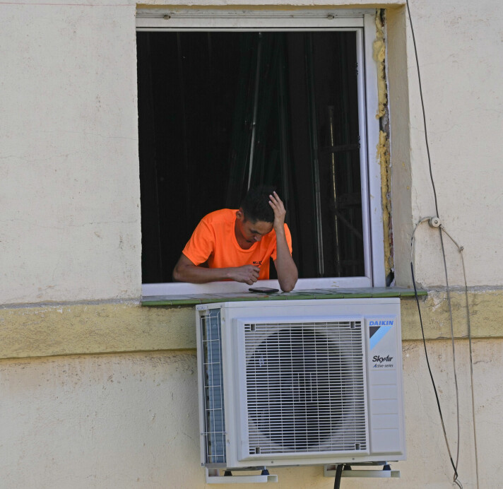 En arbeider tar en pause under installasjon av et klimaanlegg montert utenfor en leilighet i Madrid i april i år. Spania opplever i år sommertemperaturer i april, og landet står overfor nok et år med tørke og høye temperaturer.