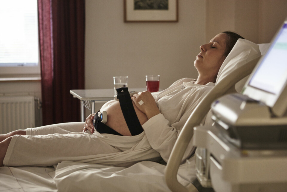Gravid kvinne på sykehus med måleinstrumenter festet til magen.