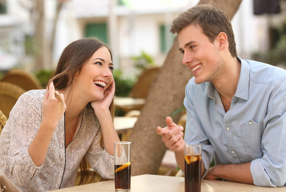 A woman and man are on a date, talking and laughing.