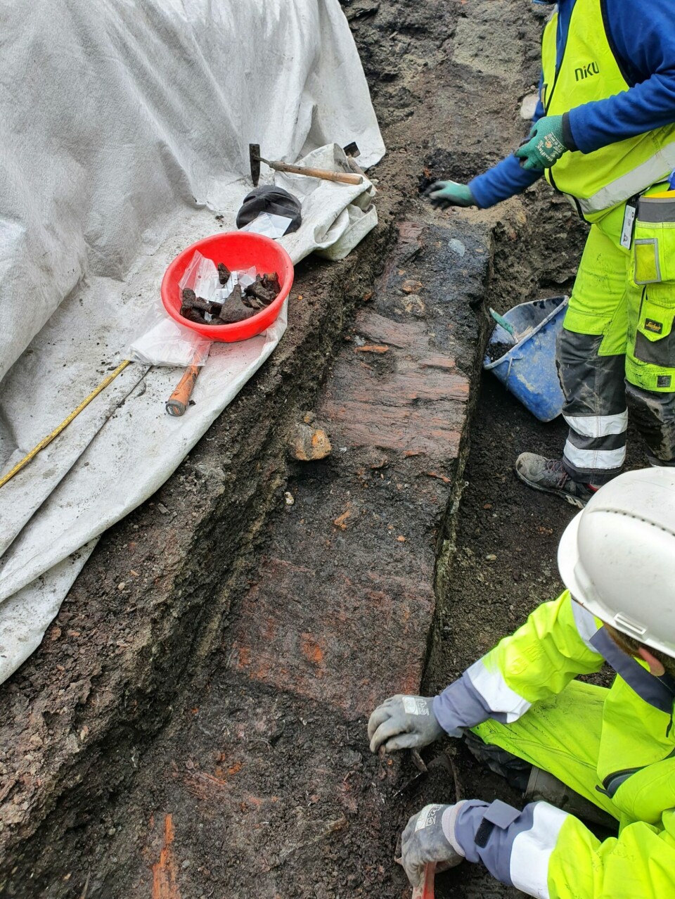 Over gropa spillebrikken ble funnet i var det plankerester etter det som trolig har vært en del av en gate, en såkalt middelalderstrete.