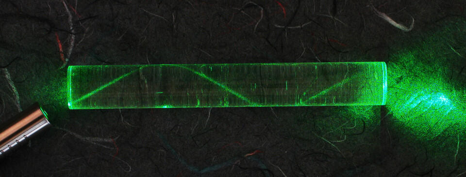 En laserstråle sendes gjennom en glass-sylinder.
