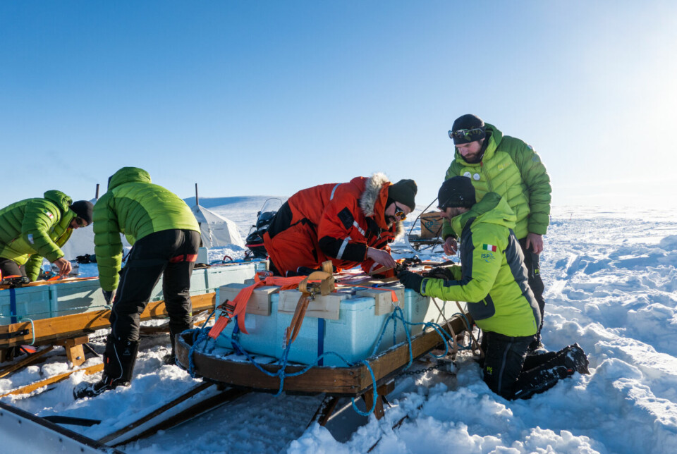 Isprøvene pakkes i polstrede kasser som stroppes på snøscootersleder, før den tre timer lange kjøreturen til Ny-Ålesund forskningsstasjon. – Vi vil komme fram med iskjerner, ikke isbiter, sier Gallet (oransje jakke).