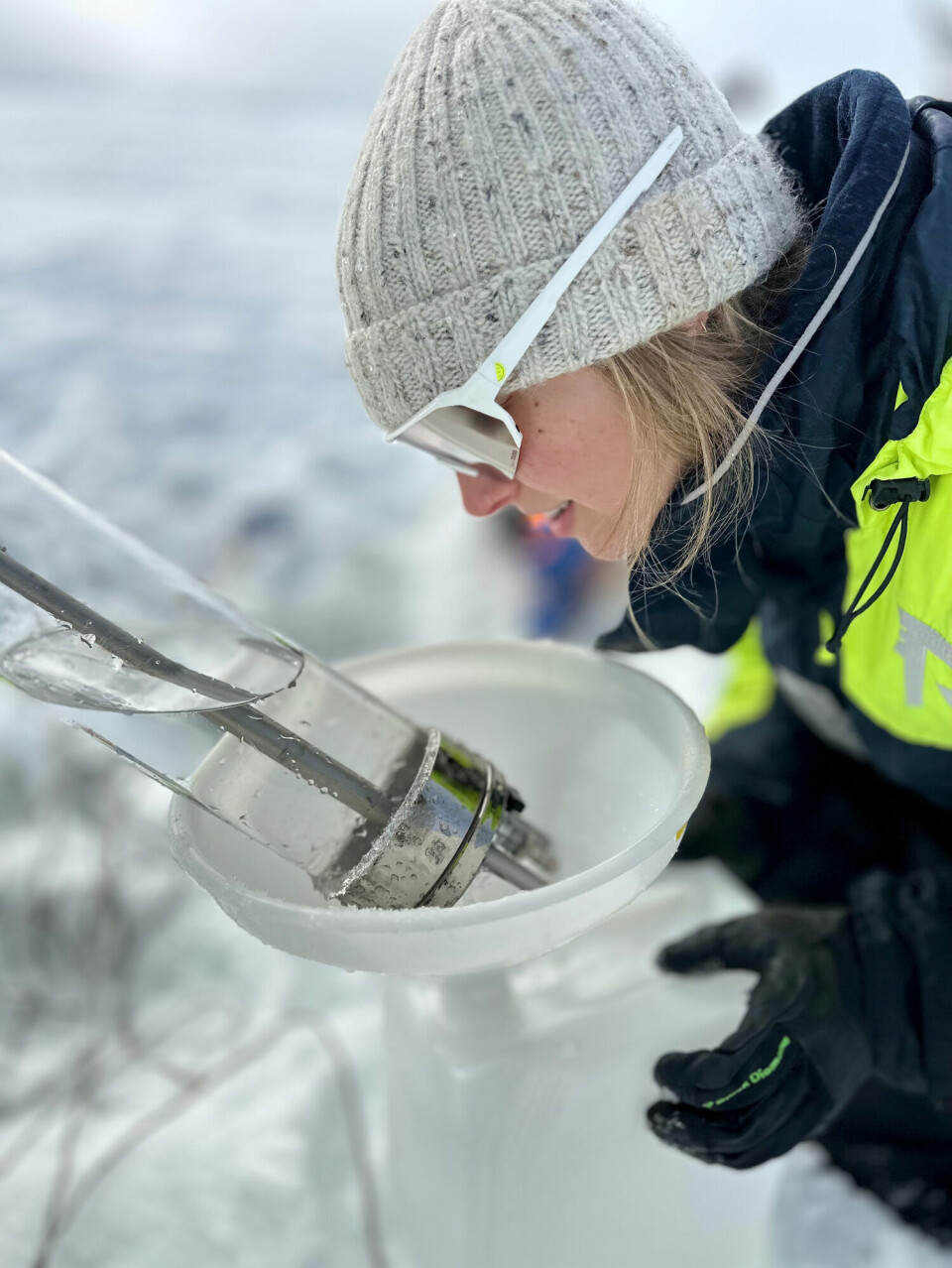 Vannprøver tas gjennom hull i isen. Megan Lenss fra Norsk Polarinstitutt følger nøye med.