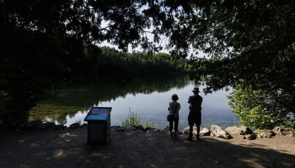 Turister ser utover den vakre Crawford-innsjøen i Canada. En forskergruppe har som mål å bestemme en spesifikk startdato for epoken antropocen, menneskets tidsalder, ved å måle plutoniumsnivåer på bunnen av Crawford Lake.