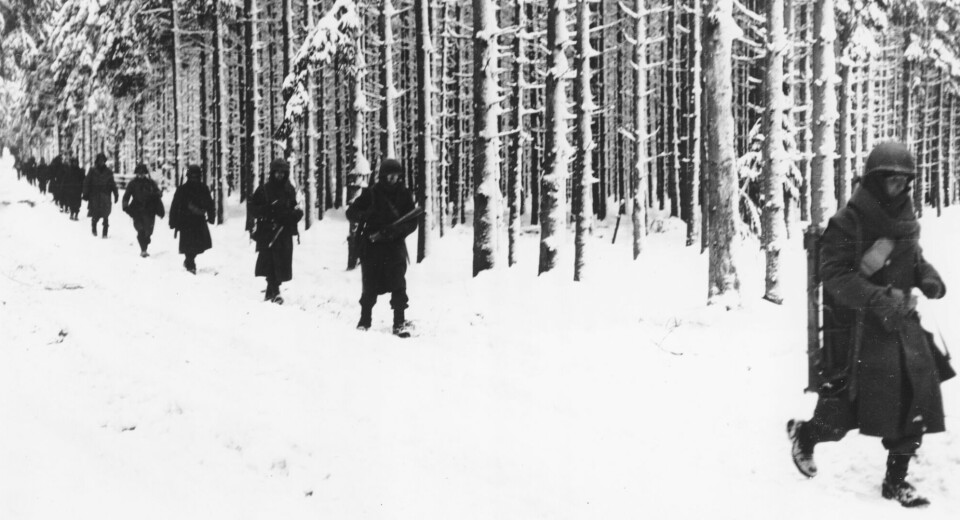 Amerikanske soldater fra den 75. divisjonen marsjerer i isende kulde gjennom skogen i nærheten av St Vith i Belgia like etter Battle of the bulge. Bildet er fra februar, 1945.