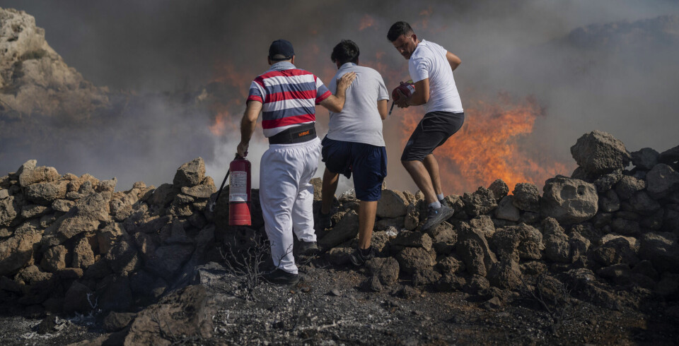 Lokale innbyggere forsøker å slukke en brann ved Lindos på Rhodos 24. juli. Brannen varte i elleve dager før de ble brakt under kontroll.