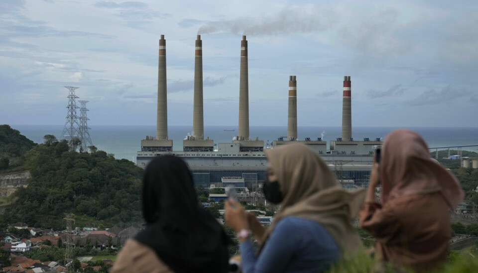 Indonesiske kvinner foran et kullkraftverk på øya Java. Produksjon av kullkraft fører til store utslipp av klimagassen CO2.