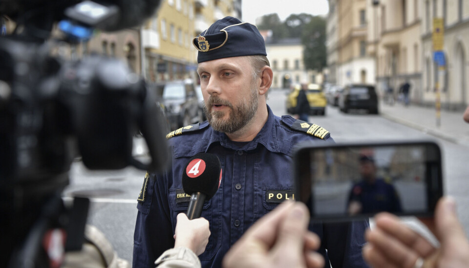 Politimann blir intervjuet av pressen.